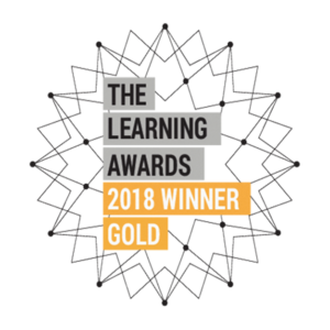Graphic with text reading 'The learning awards 2018 winner gold,' recognising Mindful Education as the winner. The text sits on top of a geometric, star-like design.