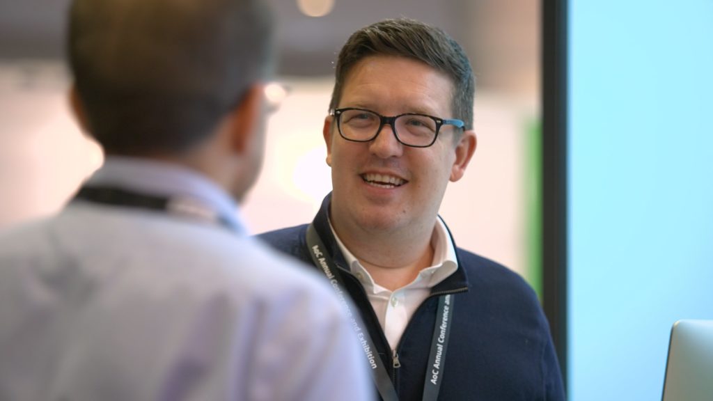 A Mindful Education employee engaging with a delegate at a professional industry event.