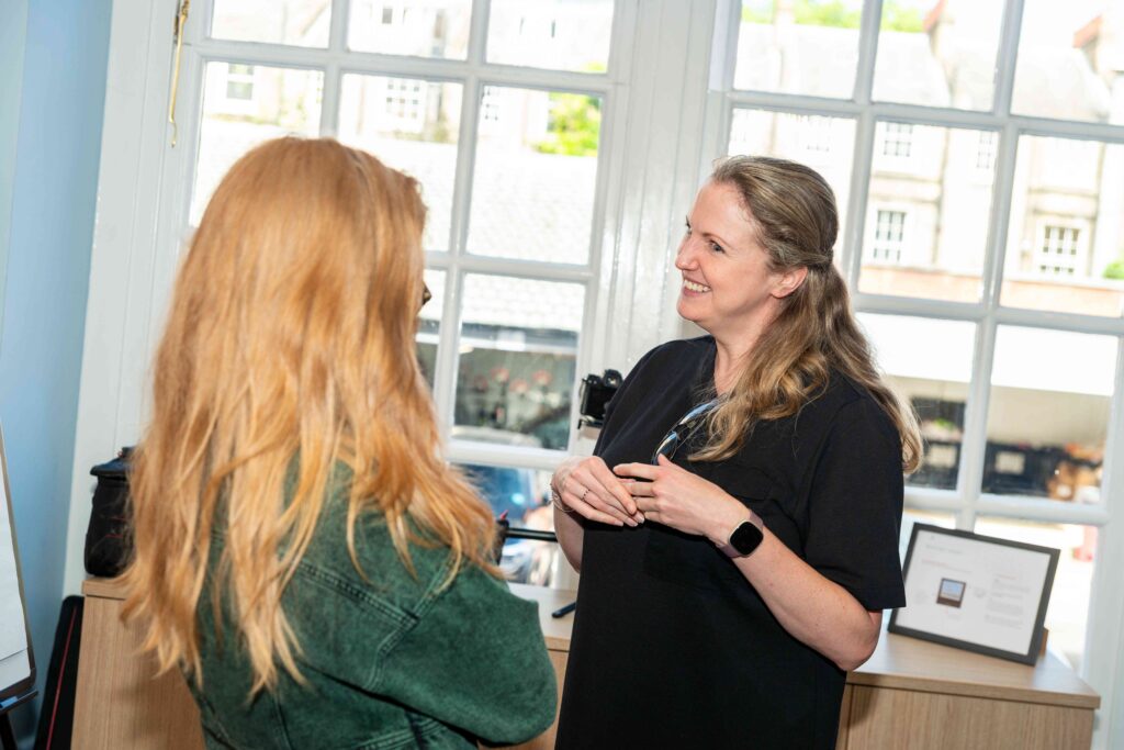 Two Mindful Education employees smiling and engaging in conversation.