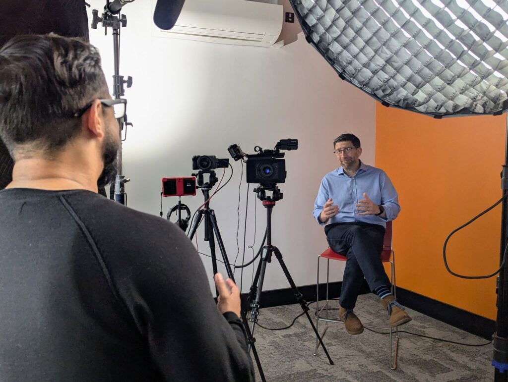 A Mindful Education employee interviewing a tutor from Activate Learning with cameras set up.