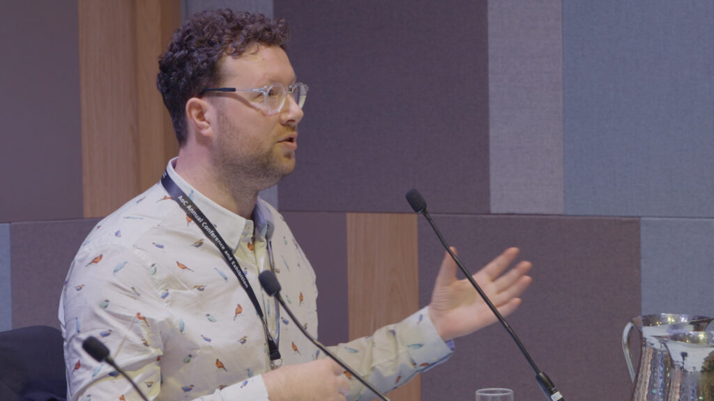 Image of an industry leader speaking to a crowd of people at the AoC Annual Conference.