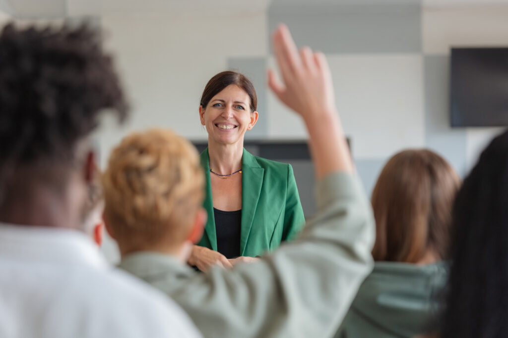 Image of a tutor teaching a classroom of learners, showing learning and leadership.