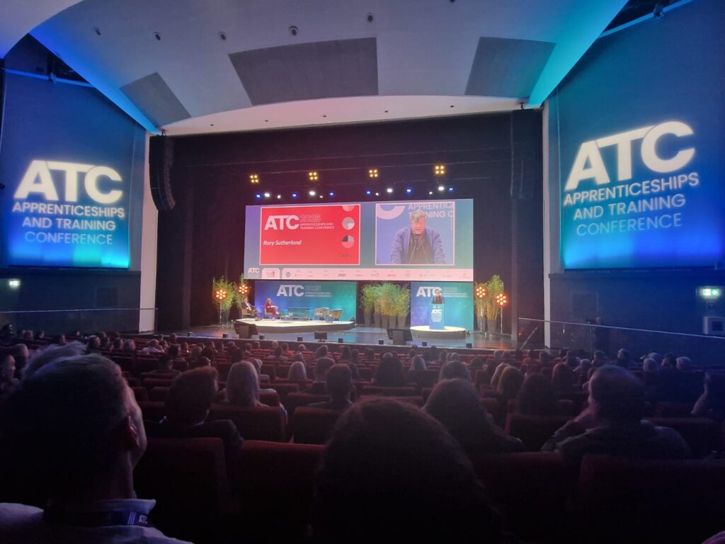 Image of a seminar taking place at an apprenticeships conference, where professionals and employers gather to network.