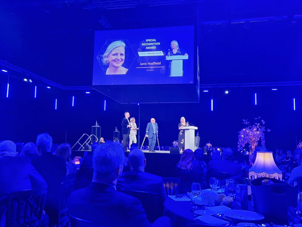 An image of a formal award ceremony where people are on stage presenting delegates and other attendees with awards.