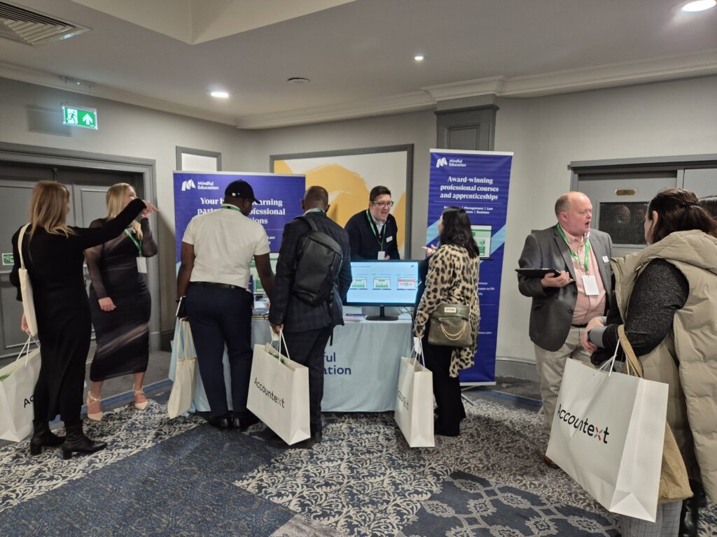 Mindful Education employees showing demos of their blended learning accounting courses to professional delegates at an industry event.