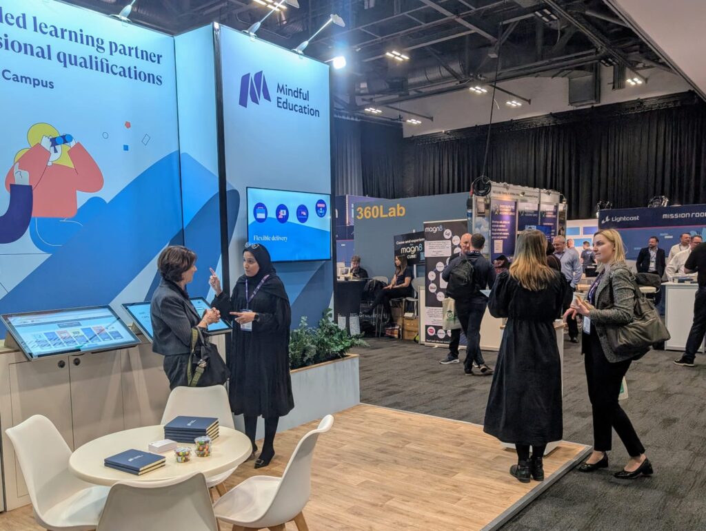 Image of Mindful Education employees speaking to delegates at an event about their blended learning apprenticeships.