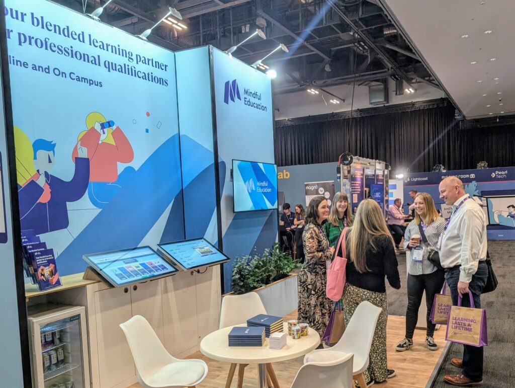 Mindful Education employees speaking to delegates at an event about their flexible and professional apprenticeships.