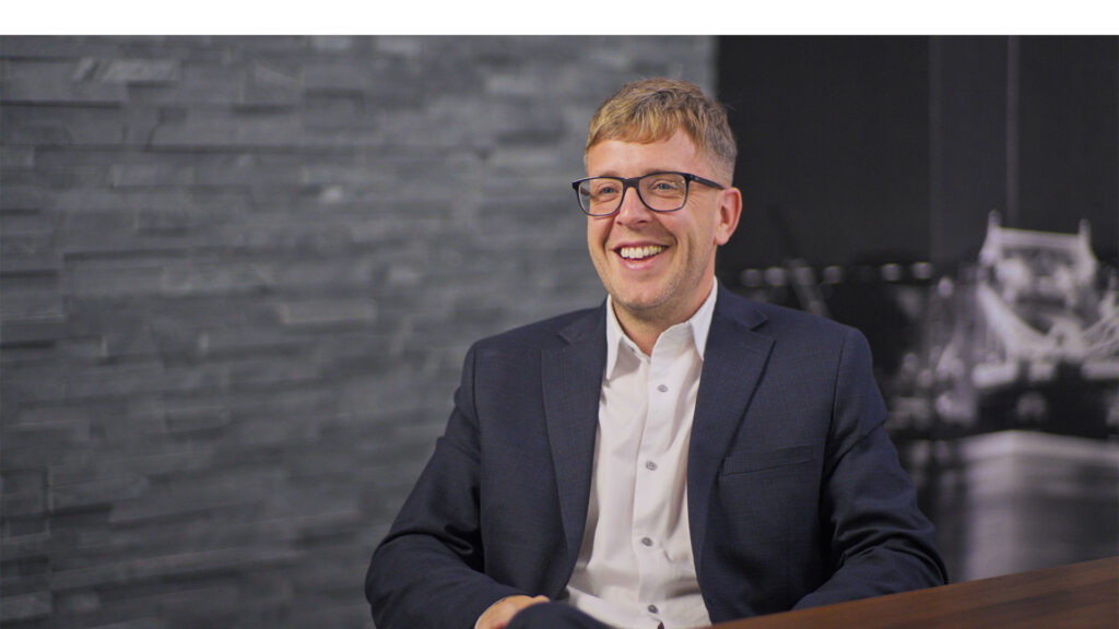 An image of a Mindful Education apprentice smiling as he prepares to speak on his apprenticeship journey.
